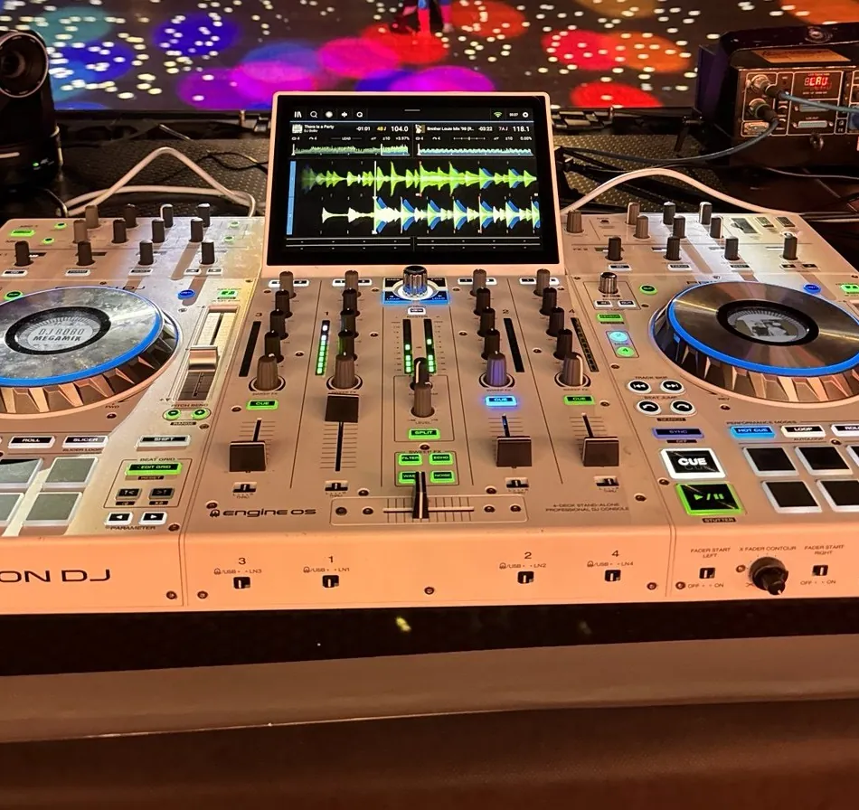 DJ pult Denon DJ Prime 4 s dotykovým displejem, za ním osvětlený parket